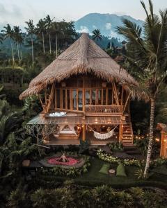 ein großes Bambushaus mit Grasdach in der Unterkunft Magic Hills Bali - Magical Eco-Luxury Lodge in Selat
