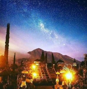 - une vue nocturne sur un complexe avec des lumières et une montagne dans l'établissement Magic Hills Bali - Magical Eco-Luxury Lodge, à Selat