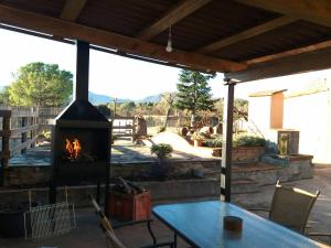 a fireplace on a patio with a table at FINCA MAS GUIXOT relax y natura in Montagut