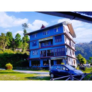 a blue building with a car parked in front of it at Khi Gha Thang in Pelling