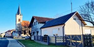 a white church with a steeple on a street at Kuća za odmor BARBARELLA in Čakovec