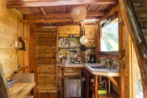 a kitchen in a log cabin with a sink and a window at Las Cabanas, Finca Flora del Rio in Pijao