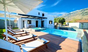 a villa with a swimming pool and a house at Perla Villas with Heated Pool in Kávallos