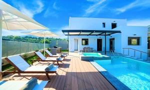 a villa with a swimming pool on a deck at Perla Villas with Heated Pool in Kávallos