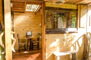 a wooden cabin with a table and a window at Cabana del Rio Lejos Pijao, Finca Flora del Rio in Pijao