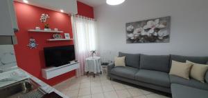 a living room with a couch and a tv at Sunset Apartment in Shëngjin