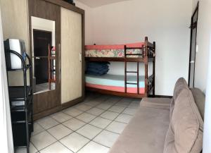 a room with two bunk beds and a refrigerator at Lindo apartamento super completo em Meia Praia, 100 metros do mar e 10 quadras do centro in Itapema