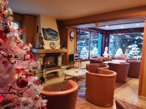 una sala de estar con un árbol de Navidad y sillas en Rezydenz, en Szklarska Poręba