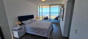 a bedroom with a bed with a view of the ocean at Apartamento frente al mar primera linea de la mansa Pda 26 punta del este penthouse in Punta del Este +25 photos