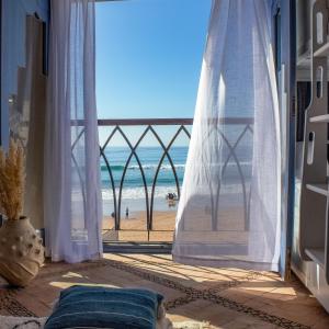 a room with a view of the beach from a window at TEDDY PIRATE - Coliving in Taghazout