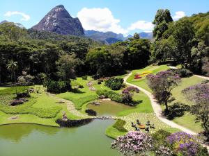un parque con un lago y montañas al fondo en Casa Marambaia Hotel, en Petrópolis