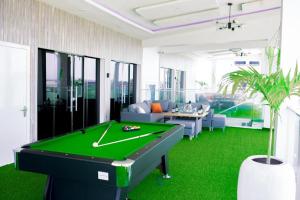 a pool table in a living room with green flooring at THE GILPINs in Lekki