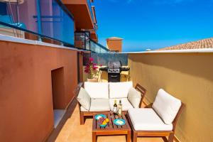 Un pequeño balcón con 2 sillas y una mesa. en Lucky Thirteen - Apartment with Ocean View en Caleta de Fuste