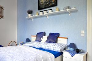 ein blaues Schlafzimmer mit einem Bett mit einem Teddybär darauf in der Unterkunft Stadtwohnung Süderbrarup in Süderbrarup
