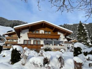 a house in the snow with snow covered trees at Haus Erler in Tux