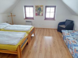 a room with three beds and a blue chair at Chata Ema in Špania Dolina