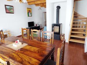 a dining room with a wooden table and a wood stove at Chata Ema in Špania Dolina