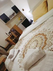 Vrnjačka BanjaにあるApartman Zvezdicaのベッドルーム1室(白と金のベッドカバー付)