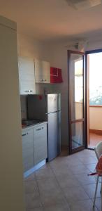 a kitchen with white appliances and a door to a balcony at A CASA DEL SOLE in Palaia