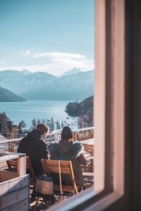 two people sitting on a bench looking out a window at la belle vue Boutique Hotel & Café in Spiez
