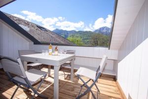 una mesa blanca y sillas en un balcón con ventana en Entre Lac et Montagnes, en Faverges