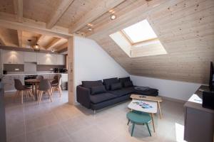 a living room with a couch and a table at Entre Lac et Montagnes in Faverges