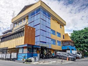 un grand bâtiment avec des fenêtres bleues sur une rue dans l'établissement Super OYO 90692 Point Hostel, à Jakarta