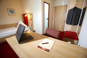 a room with a desk with a laptop computer on it at Hotel Schwanen in Kehl am Rhein