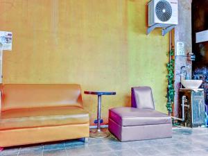a room with a couch and a chair and a table at Super OYO 90692 Point Hostel in Jakarta