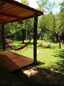 a hammock in a park with a table and benches at CASA-BOSQUE-ARROYO in Colón