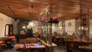 ein Restaurant mit Holzdecken, Tischen und Stühlen in der Unterkunft Gasthaus Zum Hirschen in Staufen im Breisgau