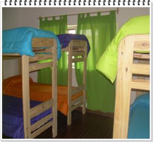 2 Etagenbetten in einem Zimmer mit grünen Vorhängen in der Unterkunft Shanti Hostel in San Rafael