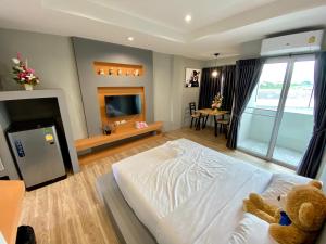 a bedroom with a bed with a teddy bear on it at แองจี้รีสอร์ท@หทัยราษฎร์ in Ban Sai Mai