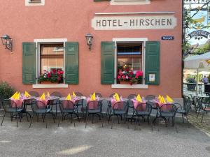 eine Gruppe von Tischen und Stühlen vor einem Gebäude in der Unterkunft Gasthaus Zum Hirschen in Staufen im Breisgau