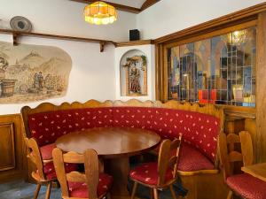 ein Restaurant mit einer roten Bank sowie einem Tisch und Stühlen in der Unterkunft Gasthaus Zum Hirschen in Staufen im Breisgau