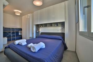 una camera da letto con un letto blu e asciugamani di Residence il Caicco a Porto Cesareo