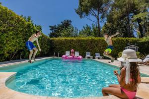 um grupo de pessoas pulando em uma piscina em Villa La Collina di Montegrappa em Tuglie