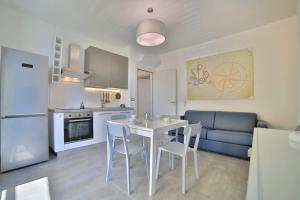 una cucina e un soggiorno con tavolo e sedie di Residence il Caicco a Porto Cesareo