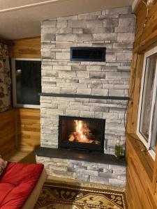 een open haard in een kamer met een stenen muur bij Villa Zeytin in Cıralı