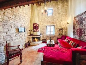 a living room with a red couch and a fireplace at Guesthouse Armakas in Kalavrita