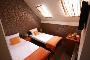 a small room with two beds and a table at Rustika Sobe in Osijek