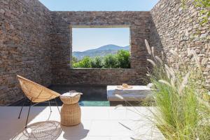 a patio with a pool and chairs and a window at NOS Hotel & Villas in Sifnos