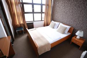 a bedroom with a large bed with a window and a bed sidx sidx at Rustika Sobe in Osijek +17 photos