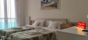 Duas camas num quarto branco com uma secretária e uma secretária. em Casa in Fiera em Foggia