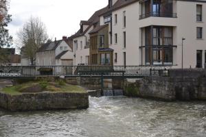 a river in a town with houses and a bridge at L'essentiel de Chartres in Chartres
