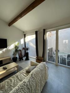 ein Wohnzimmer mit einem Sofa und einem Tisch in der Unterkunft Maison Poissonnerie in Le Grau-du-Roi