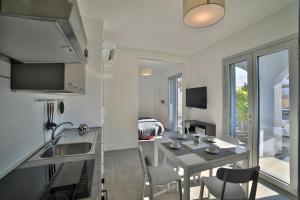 a kitchen and living room with a table and chairs at Residence IL CAICCO in Porto Cesareo