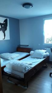 twee bedden in een kamer met een blauw licht bij Maison familiale avec piscine chauffée in Saint-Georges-de-Didonne