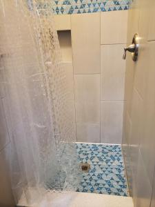 a bathroom with a shower with a glass door at Gaslamp Hostel in San Diego
