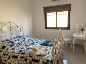 a bedroom with a bed and a desk and a window at Two bedroom Duplex :Mountain and Sea view in Larnaca